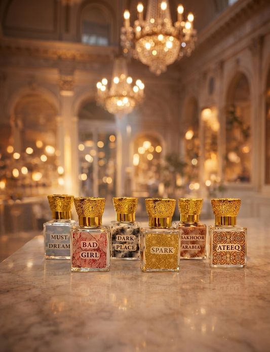 Row of perfume bottles with gold caps on a marble surface in an elegant interior setting.