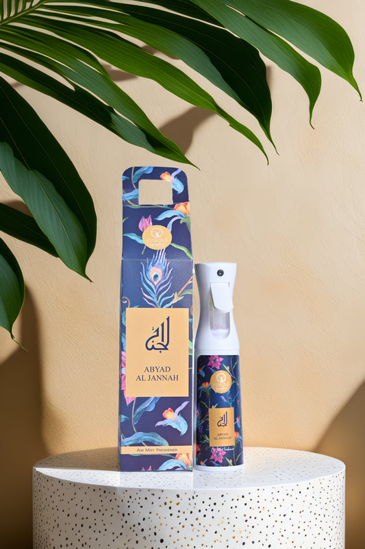 Aromatherapy spray bottle and packaging on a white surface with green leaves in the background