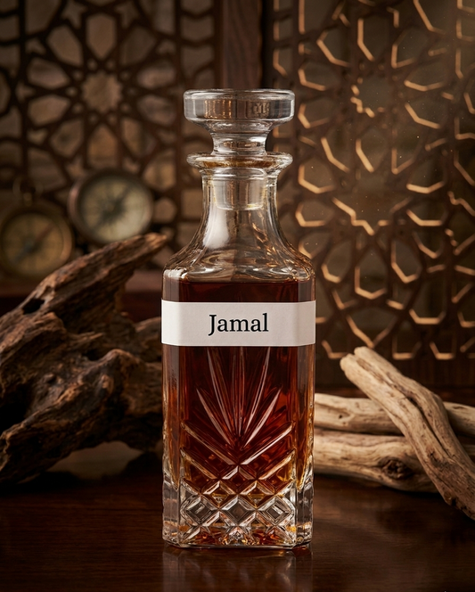 Glass decanter with 'Jamal' label against a decorative background