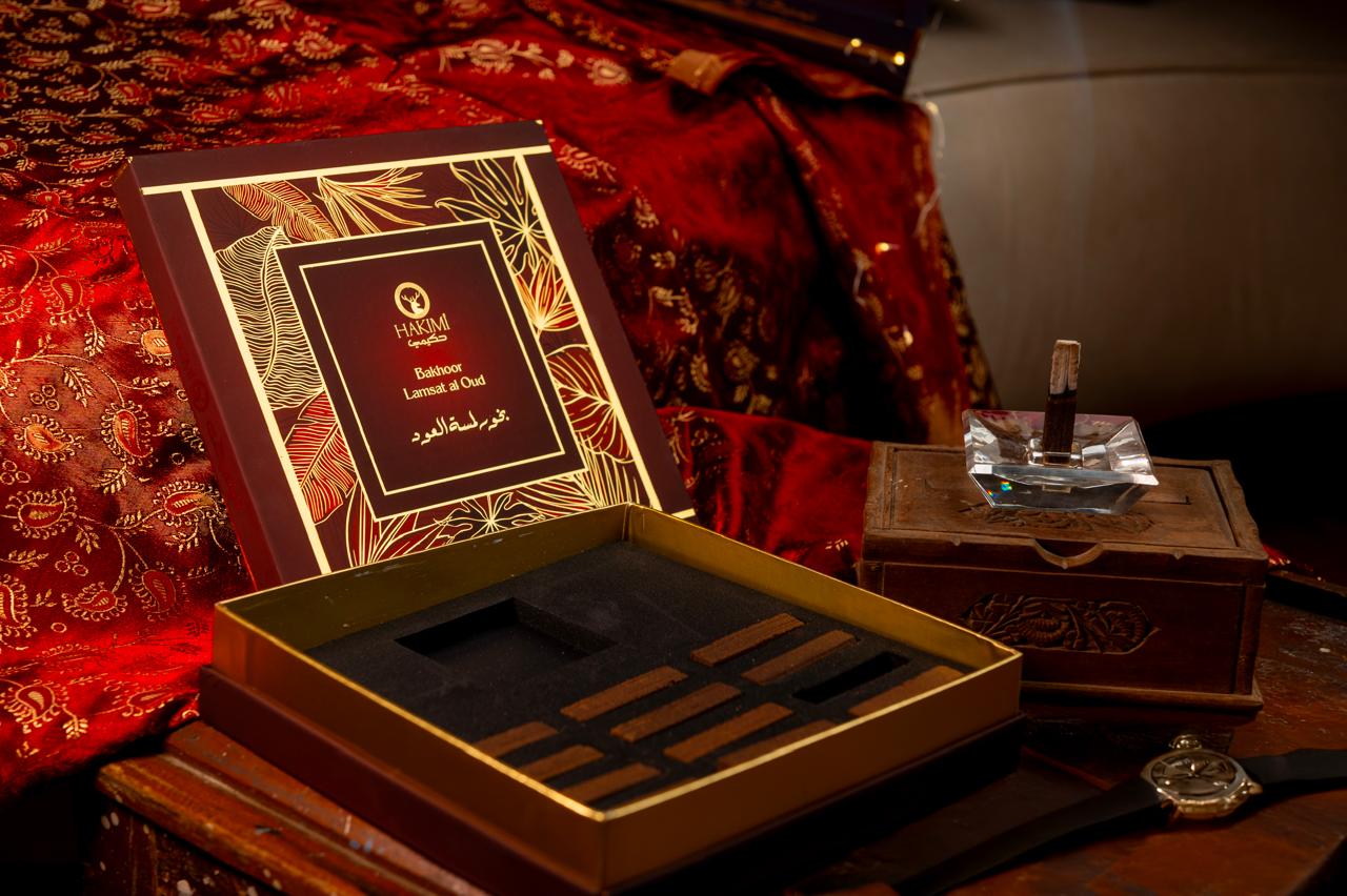 Luxury perfume set with decorative box on a richly patterned fabric background