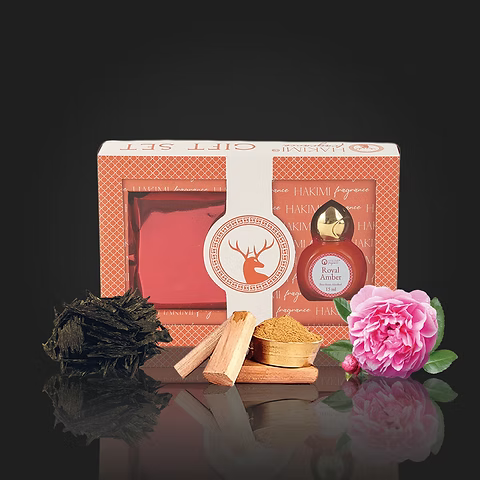 Gift set with a bottle, wooden items, and a pink flower on a dark background
