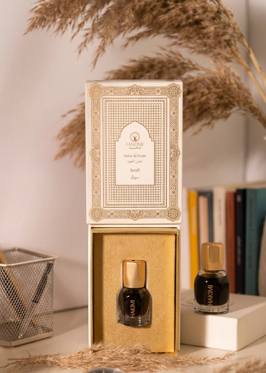 Perfume bottle with gold cap and decorative box on a neutral background