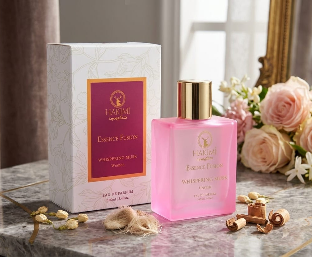 Pink perfume bottle with gold cap on a marble surface, next to a white box and flowers.