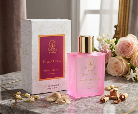 Pink perfume bottle with gold cap on a marble surface, next to a white box and flowers.